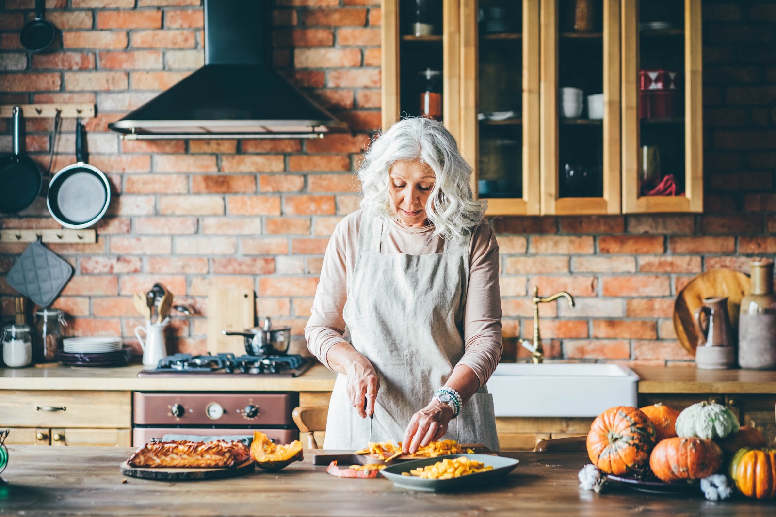 Aged Woman in White Cutting Yellow Pumpkin Again